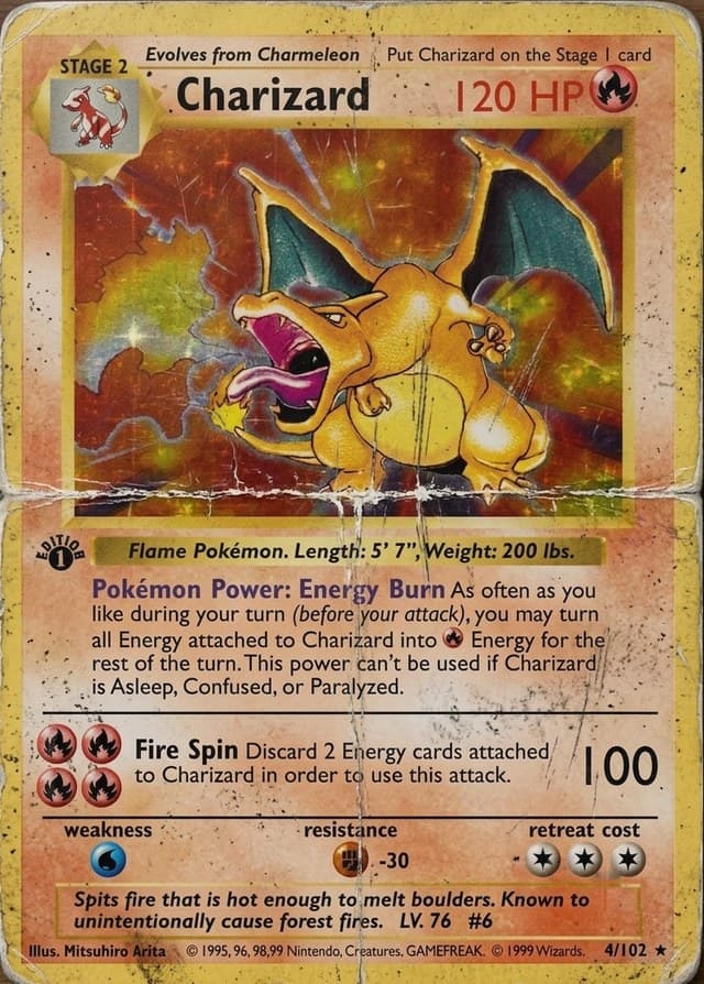 Damaged 1st Edition Charizard card with creases, worn corners and surface grime